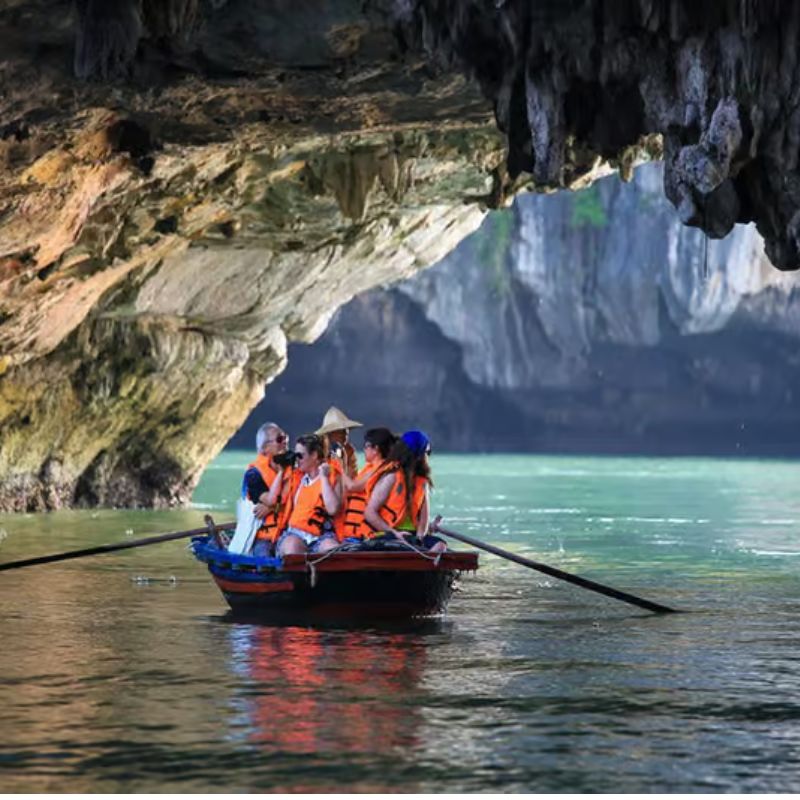 5. Luon Cave: A Gateway to a Secret Lagoon Location: Bo Hon Island (near Titop Island) Why Visit: A unique sea tunnel explored exclusively by bamboo boat or kayak. Unlike dry caverns, Luon Cave is a low-hanging archway that leads into a secluded, emerald lagoon completely encircled by sheer, forested cliffs: Wildlife Encounters: Golden monkeys are frequently spotted leaping along the cliffside trees. Mirror-Like Waters: The still water provides flawless reflections for photography. Unique Passage: Experience the thrill of crouching low on a boat to glide underneath the stone arch. Recommended Itineraries: A signature stop on most premium 2-day and 3-day cruise programs.